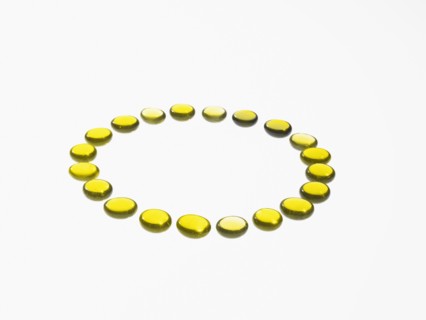 Studio shot of yellow glass beads in circle. Photo : David Arky