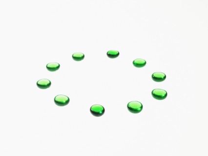 Studio shot of green glass beads in circle. Photo : David Arky