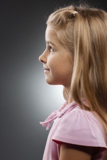 Girl (8-9) looking up, studio shot. Photo : FBP