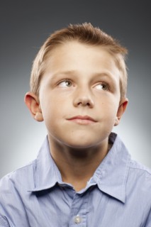 Portrait of boy (8-9) wearing shirt and looking away, studio shot. Photo : FBP