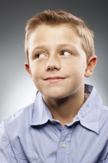 Portrait of boy (8-9) wearing shirt and looking away, studio shot. Photo : FBP
