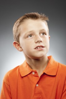 Portrait of boy (8-9) wearing polo shirt and looking away, studio shot. Photo : FBP