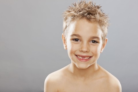 Studio portrait of toothless boy (8-9) smiling. Photo : FBP
