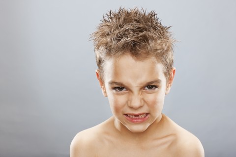 Studio portrait of angry toothless boy (8-9) . Photo : FBP
