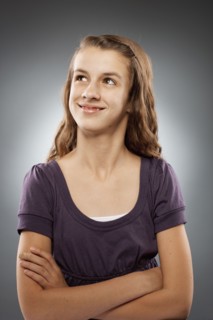 Portrait of girl (12-13) looking at camera with arms crossed, studio shot. Photo : FBP