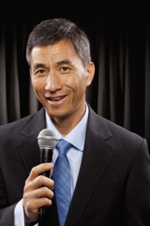 USA, Utah, Provo, Portrait of businessman with microphone standing in front of black curtain. Photo