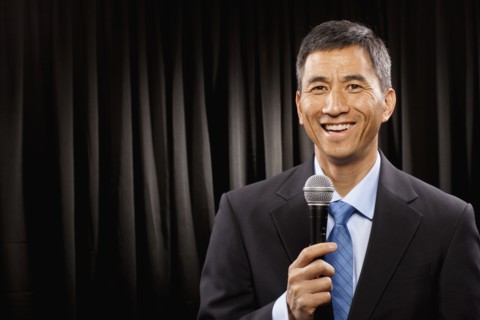 USA, Utah, Provo, Portrait of businessman with microphone standing in front of black curtain. Photo