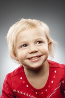 Portrait of happy girl (2-3) looking up, studio shot. Photo : FBP