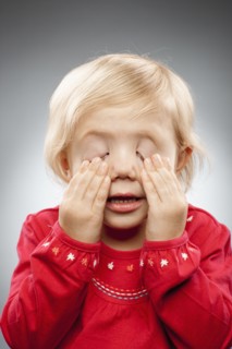 Portrait of girl (2-3) with hands covering eyes, studio shot. Photo : FBP