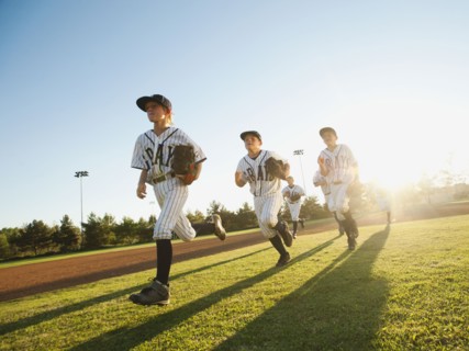 Baseball players (10-11) running on baseball diamond.