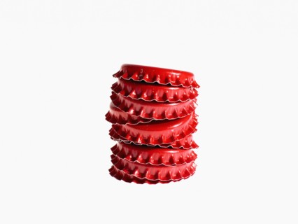 Studio shot of heap of red bottle caps. Photo : David Arky