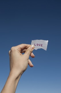 USA, Arizona, Winslow, Human hand holding love note against blue sky. Photo : David Engelhardt