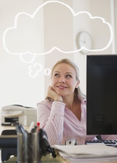 USA, New Jersey, Jersey City, Young attractive businesswoman daydreaming in office. Photo : Jamie