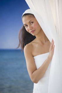 USA, New Jersey, Jersey City, Portrait of woman peering around curtain near sea.