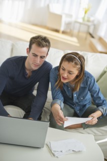 USA, New Jersey, Jersey City, Portrait of young couple doing paperwork at home.