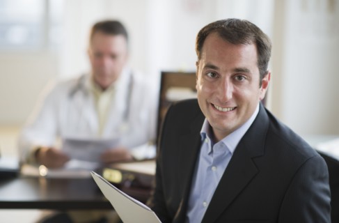 USA, New Jersey, Jersey City, Portrait of male patient holding medical results in office.