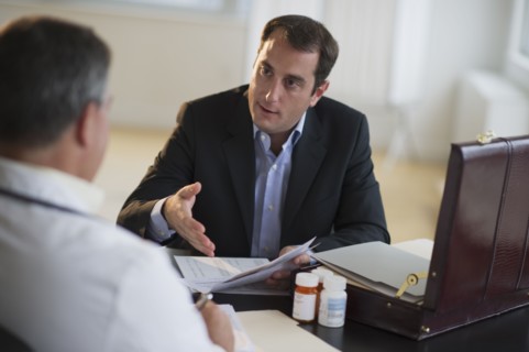 USA, New Jersey, Jersey City, Medical sales representative talking with doctor in office.