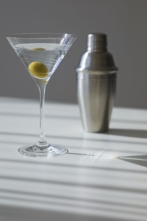 Cocktail shaker and cocktail in glass.