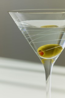 Cocktail with olive in glass.