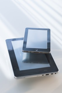 Two digital tablets reflecting light.