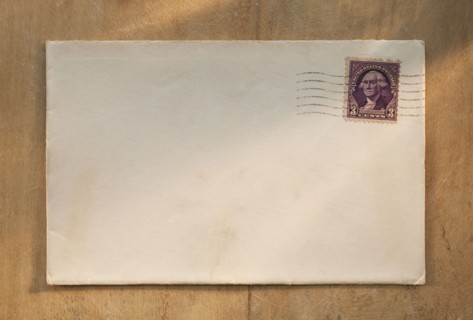 Blank envelope on wooden table.