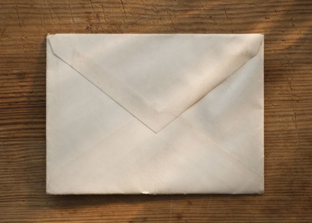 Blank envelope on wooden table.