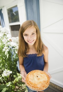 USA, New York, Girl (10-11) holding apple pie. Photo : Jamie Grill Photography