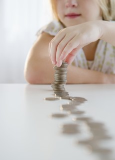 USA, New Jersey, Jersey City, Girl (8-9) playing with coins. Photo : Jamie Grill Photography