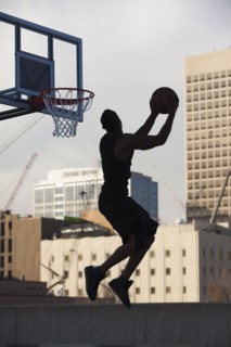 USA, Utah, Salt Lake City, Silhouette of young man playing basketball. Photo : Mike Kemp