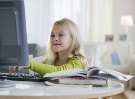 USA, New Jersey, Jersey City, Girl (8-9) sitting in front of computer. Photo : Jamie Grill
