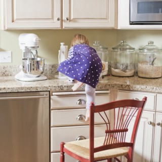 USA, Utah, Girl (2-3) climbing on cupboard in kitchen. Photo : Tim Pannell