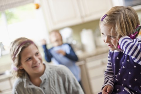USA, Utah, Two girls (2-3, 10-11) in kitchen. Photo : Tim Pannell