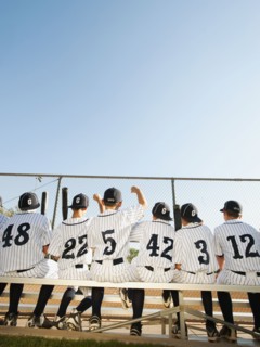 USA, California, Ladera Ranch, Boys (10-11) from little league sitting on bench, rear view.