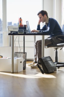 USA, New Jersey, Jersey City, Young man working on laptop in office.