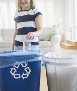USA, New Jersey, Jersey City, Girl (8-9) putting plastic bottle into recycling bin. Photo : Jamie