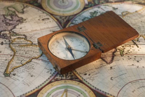 Antique compass on map.