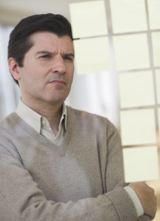USA, New Jersey, Jersey City, Businessman observing adhesive notes on window.