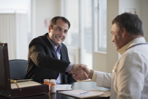 USA, New Jersey, Jersey City, Medical sales representative shaking hands with doctor in office.