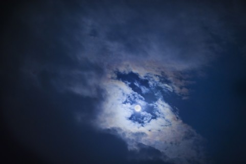 Full moon in cloudy sky at night.