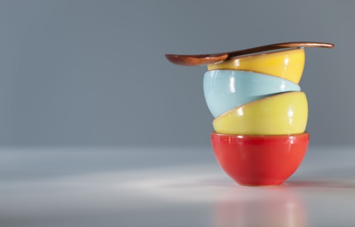 Colorful stacked bowls with spoon.