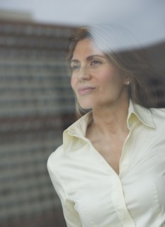USA, New Jersey, Jersey City, Businesswoman looking through window.