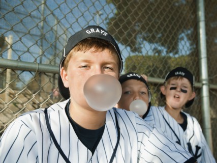 USA, California, Ladera Ranch, Boys (10-11) from little league sitting on dugout and blowing bubble