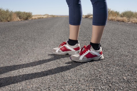 USA, Arizona, Winslow, Mid adult woman wearing spots shoes standing, low section. Photo : David