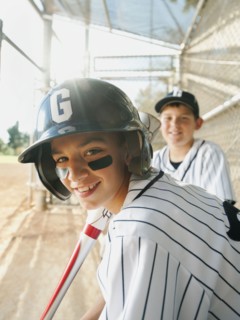 USA, California, Ladera Ranch, boys (10-11) from little league baseball team on dugout.