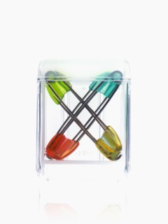 Studio shot of safety pins in glass cube. Photo : David Arky