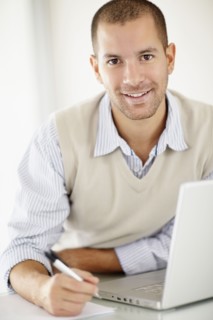 South Africa, Portrait of young man with laptop. Photo : momentimages