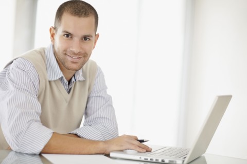South Africa, Portrait of young man with laptop. Photo : momentimages