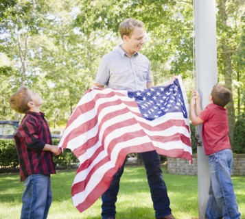 USA, New York, Flanders, Father with two boys (4-5, 8-9) hanging American flag on pole. Photo :