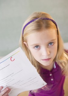 USA, New Jersey, Jersey City, Sad schoolgirl (8-9) showing test results with C-grade. Photo : Jamie