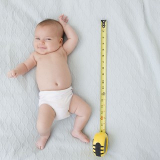 USA, New Jersey, Jersey City, baby girl laying (2-5 months) laying next to measuring tape. Photo :